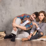 young-couple-sitting-floor-with-books_114579-58534